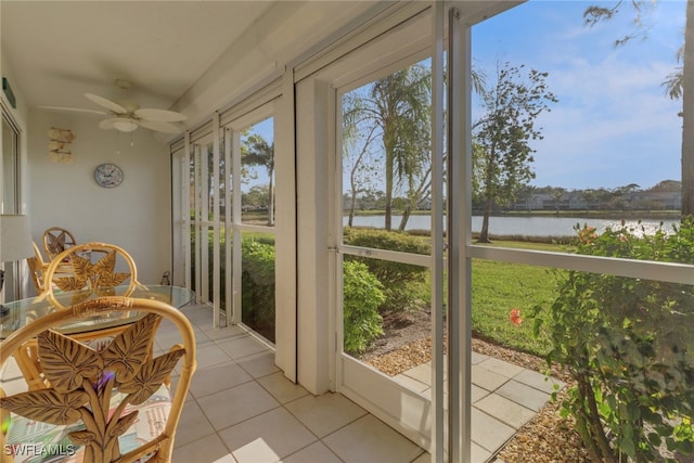 sunroom / solarium with a water view, ceiling fan, and a healthy amount of sunlight