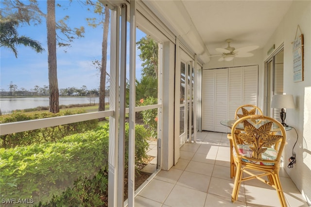 sunroom featuring a water view and ceiling fan