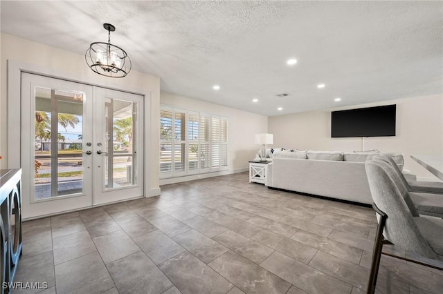 unfurnished living room featuring plenty of natural light, french doors, and a textured ceiling