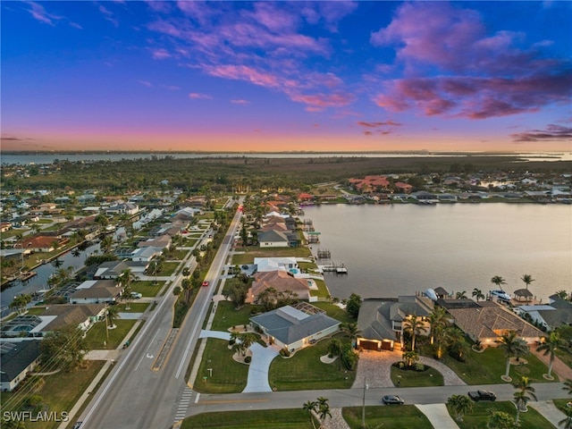 aerial view at dusk featuring a water view