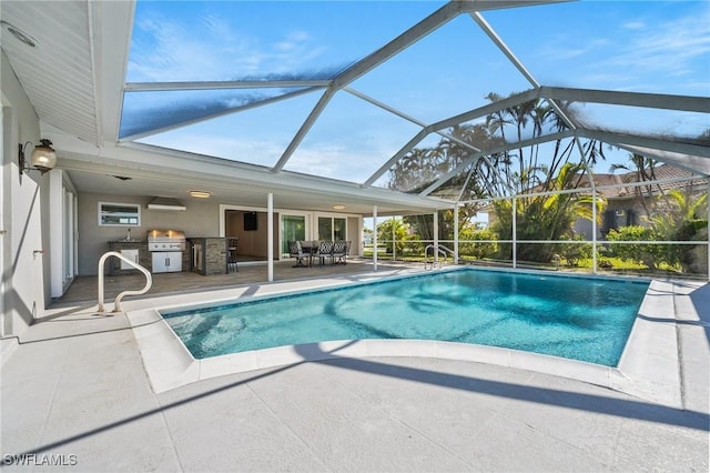 view of pool featuring a patio, an outdoor kitchen, area for grilling, and glass enclosure