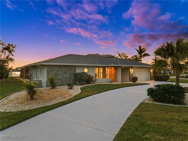 ranch-style home featuring a garage and a yard