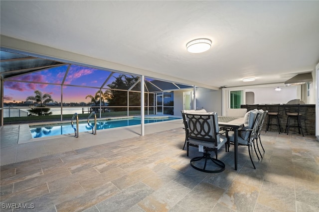 interior space featuring a water view, an outdoor bar, and glass enclosure