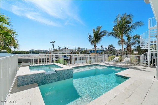 view of swimming pool with an in ground hot tub, a water view, and a patio area