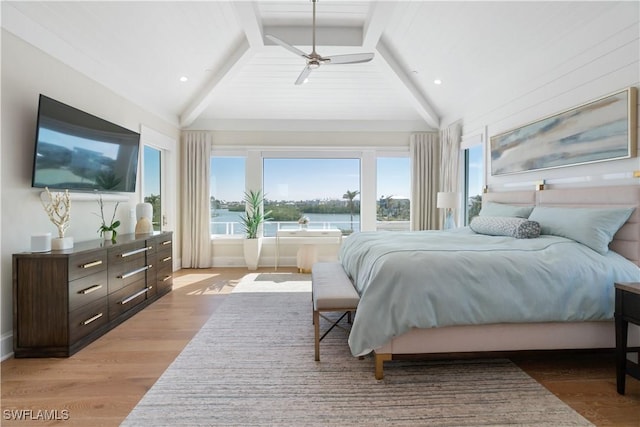 bedroom with high vaulted ceiling, light wood-type flooring, ceiling fan, a water view, and beam ceiling