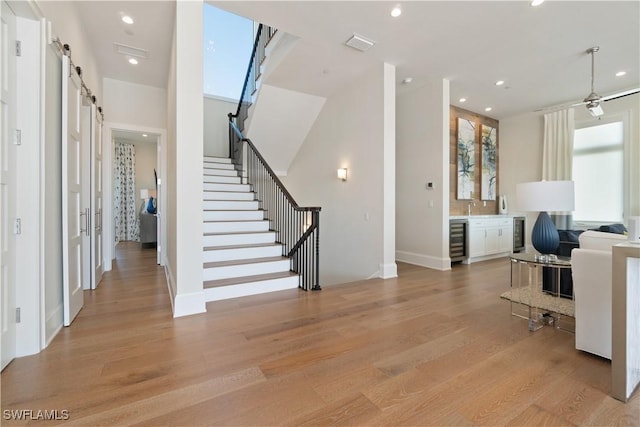 5997 Cypress Ln, Bonita Springs, FL 34134 - home office with a barn door, a healthy amount of sunlight, light wood finished floors, and wine cooler