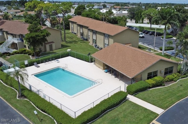 view of pool with a patio and a lawn