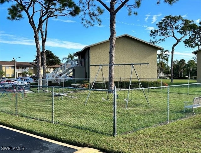 view of home's exterior with a lawn and a playground