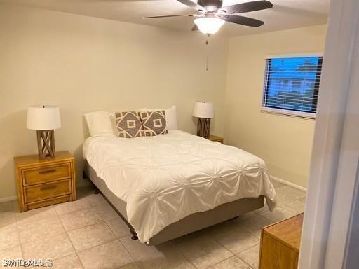 tiled bedroom featuring ceiling fan