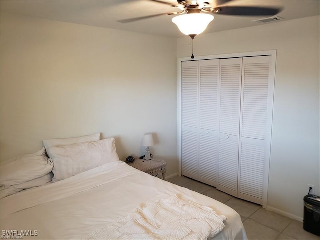 bedroom featuring light tile patterned floors, ceiling fan, and a closet