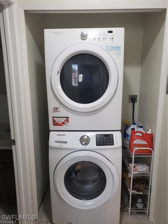 clothes washing area with stacked washer / dryer