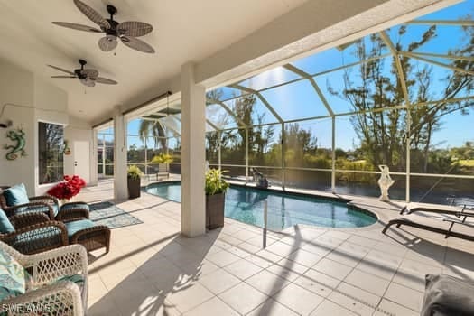 view of pool featuring a patio, ceiling fan, and glass enclosure