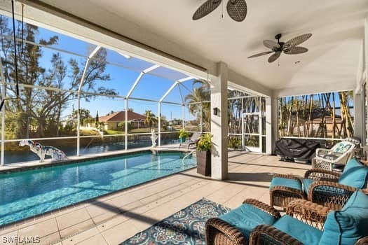 view of swimming pool with outdoor lounge area, ceiling fan, a lanai, and a patio