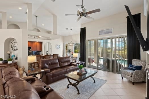 living room with light tile patterned floors, ceiling fan, and a high ceiling