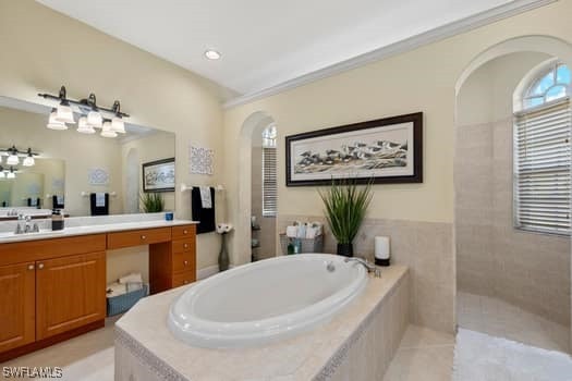 bathroom featuring independent shower and bath, vanity, and tile patterned floors