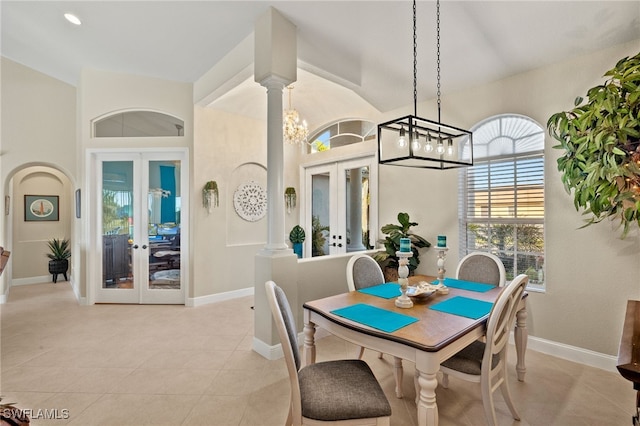 tiled dining area with a notable chandelier, french doors, and ornate columns