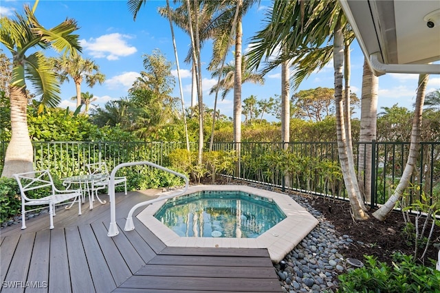 view of swimming pool with a deck and an in ground hot tub