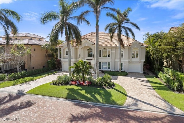 mediterranean / spanish-style house with a garage and a front yard