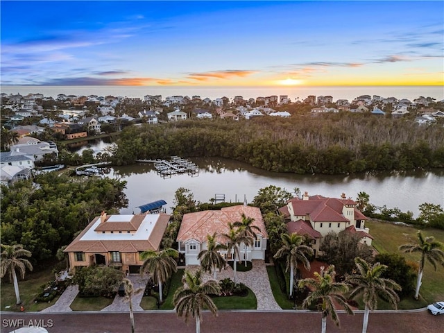 aerial view at dusk featuring a water view