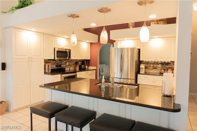 kitchen featuring light tile patterned flooring, appliances with stainless steel finishes, sink, and white cabinets