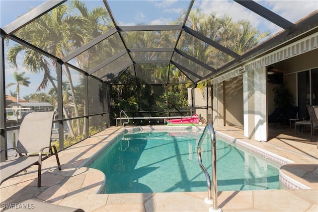 view of swimming pool featuring a patio and glass enclosure