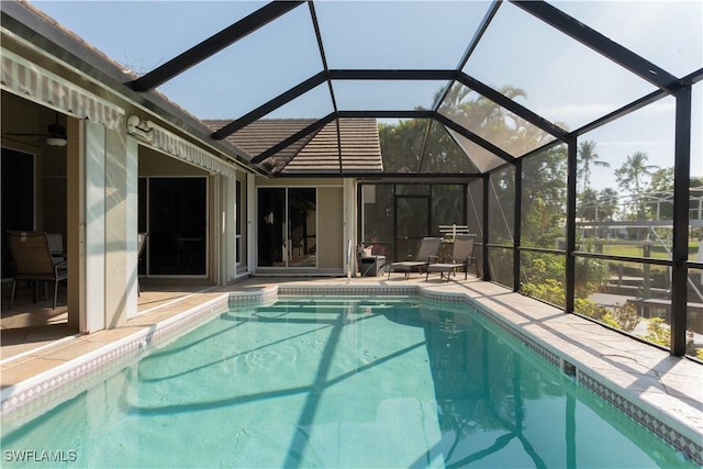 view of swimming pool featuring a patio and glass enclosure