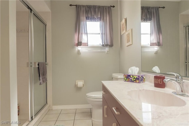 bathroom featuring tile patterned flooring, vanity, a shower with shower door, and toilet