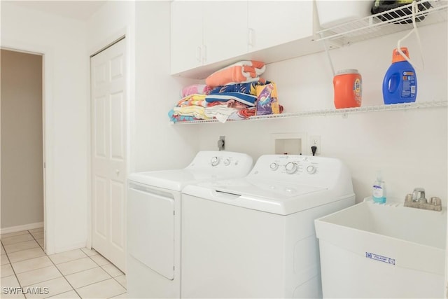 clothes washing area featuring cabinets, independent washer and dryer, sink, and light tile patterned floors