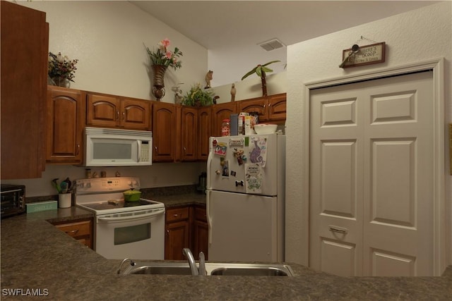 kitchen featuring white appliances and sink