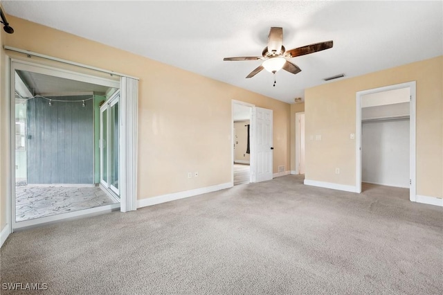 unfurnished bedroom featuring access to exterior, visible vents, carpet flooring, ceiling fan, and baseboards