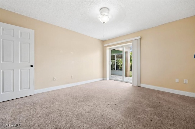 carpeted empty room with baseboards and a textured ceiling