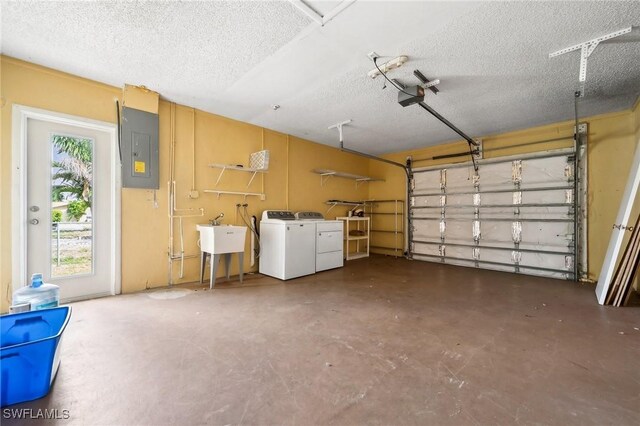 garage featuring electric panel, separate washer and dryer, a sink, and a garage door opener