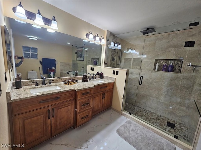 bathroom featuring vanity, a shower with shower door, and toilet