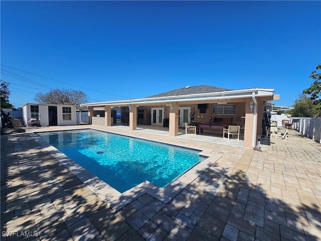 view of swimming pool with a patio, outdoor lounge area, and an outbuilding