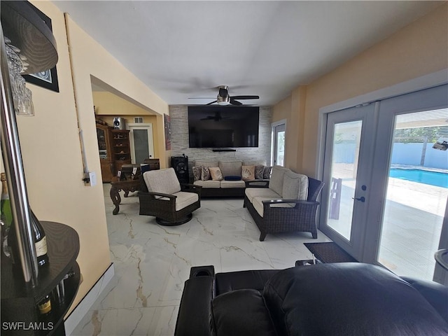 living room featuring french doors, ceiling fan, and a wealth of natural light