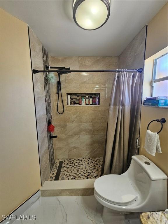 bathroom featuring toilet and a shower with shower curtain