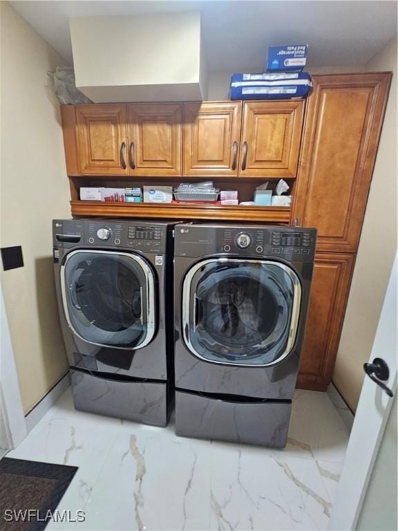 laundry area with independent washer and dryer and cabinets