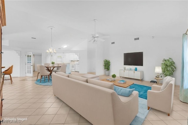 living area with ceiling fan with notable chandelier, visible vents, vaulted ceiling, and light tile patterned floors