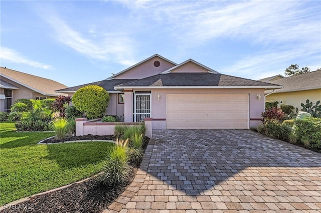 9439 Palm Island Cir, North Fort Myers, FL 33903 - ranch-style house featuring decorative driveway, stucco siding, a front yard, and an attached garage