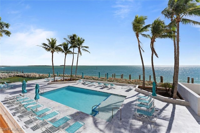 view of swimming pool with a water view and a patio area