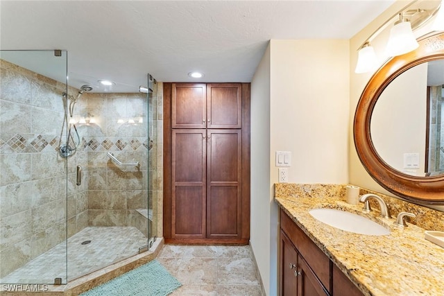 bathroom featuring vanity, tile patterned floors, an enclosed shower, and a textured ceiling