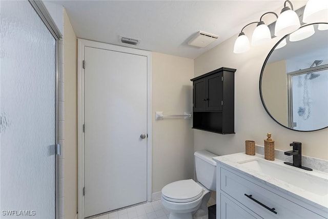 bathroom featuring vanity, an enclosed shower, and toilet