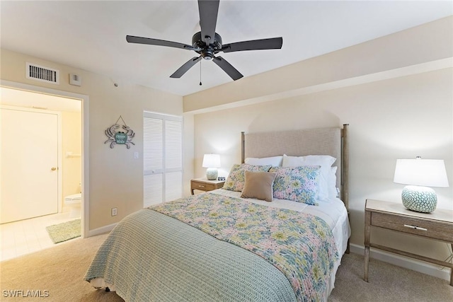 bedroom with connected bathroom, light colored carpet, and ceiling fan