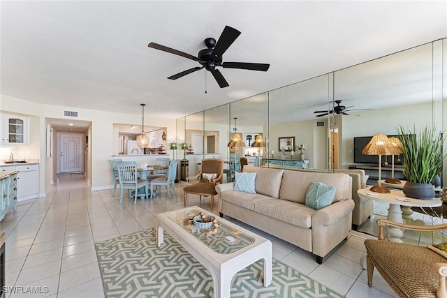 living room with ceiling fan and light tile patterned flooring