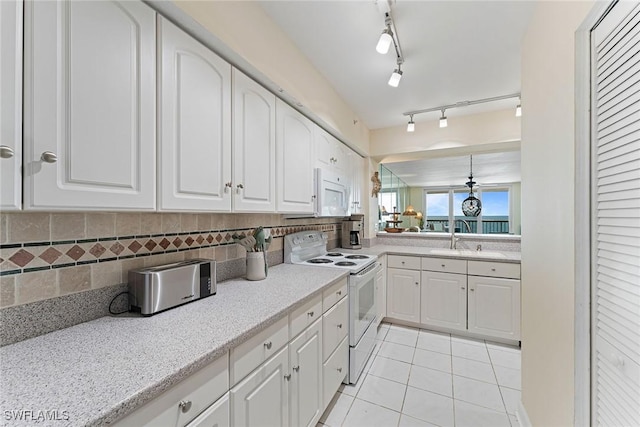 kitchen with white cabinetry, sink, and white appliances