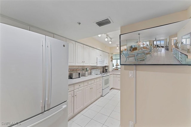 kitchen with white cabinetry, backsplash, white appliances, and light tile patterned flooring