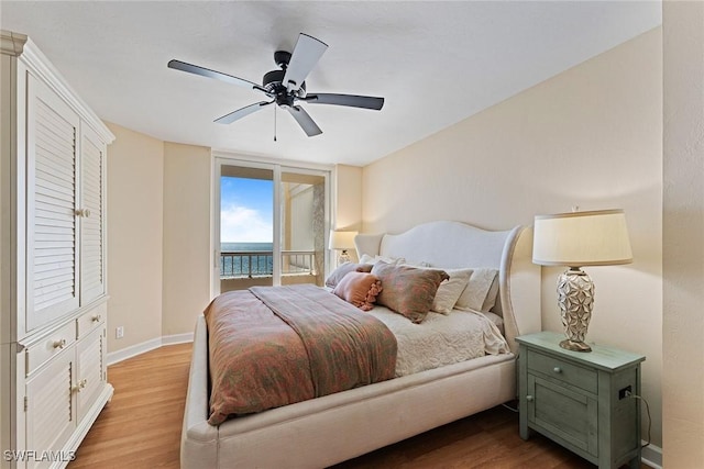 bedroom with ceiling fan, a water view, access to exterior, and light wood-type flooring