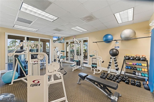 workout area with a paneled ceiling and a wealth of natural light