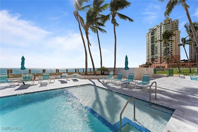 view of pool with a patio and a water view