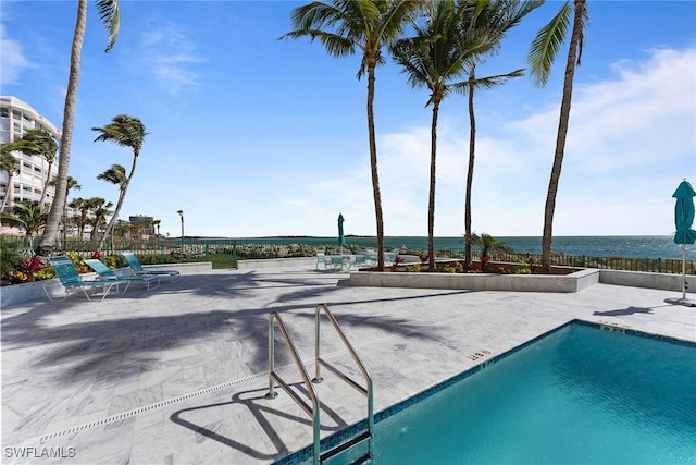 view of pool with a water view and a patio area